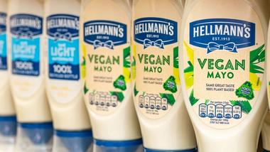 Hellmann's Vegan Mayo und Hellmann's Light Mayo-Packungen in einem Supermarktregal.