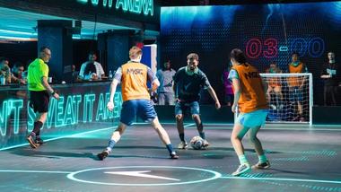 Männer spielen auf einem LED-Fußballfeld in Unilevers House of Fresh. Auf dem Boden leuchtet ein Rexona-Logo.