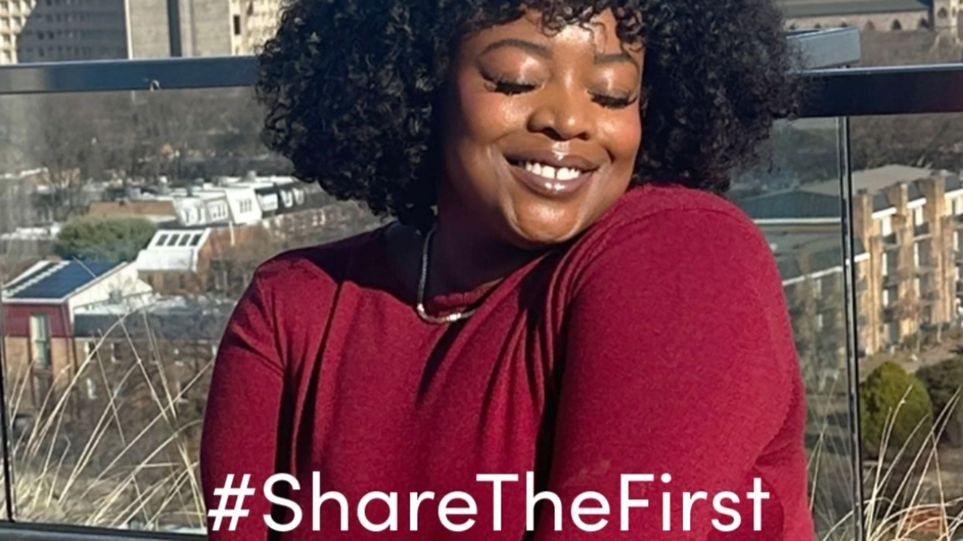 Ein Selfie einer Frau in einem roten Kleid mit dunklem, lockigem Haar mit der Tagline #ShareTheFirst
