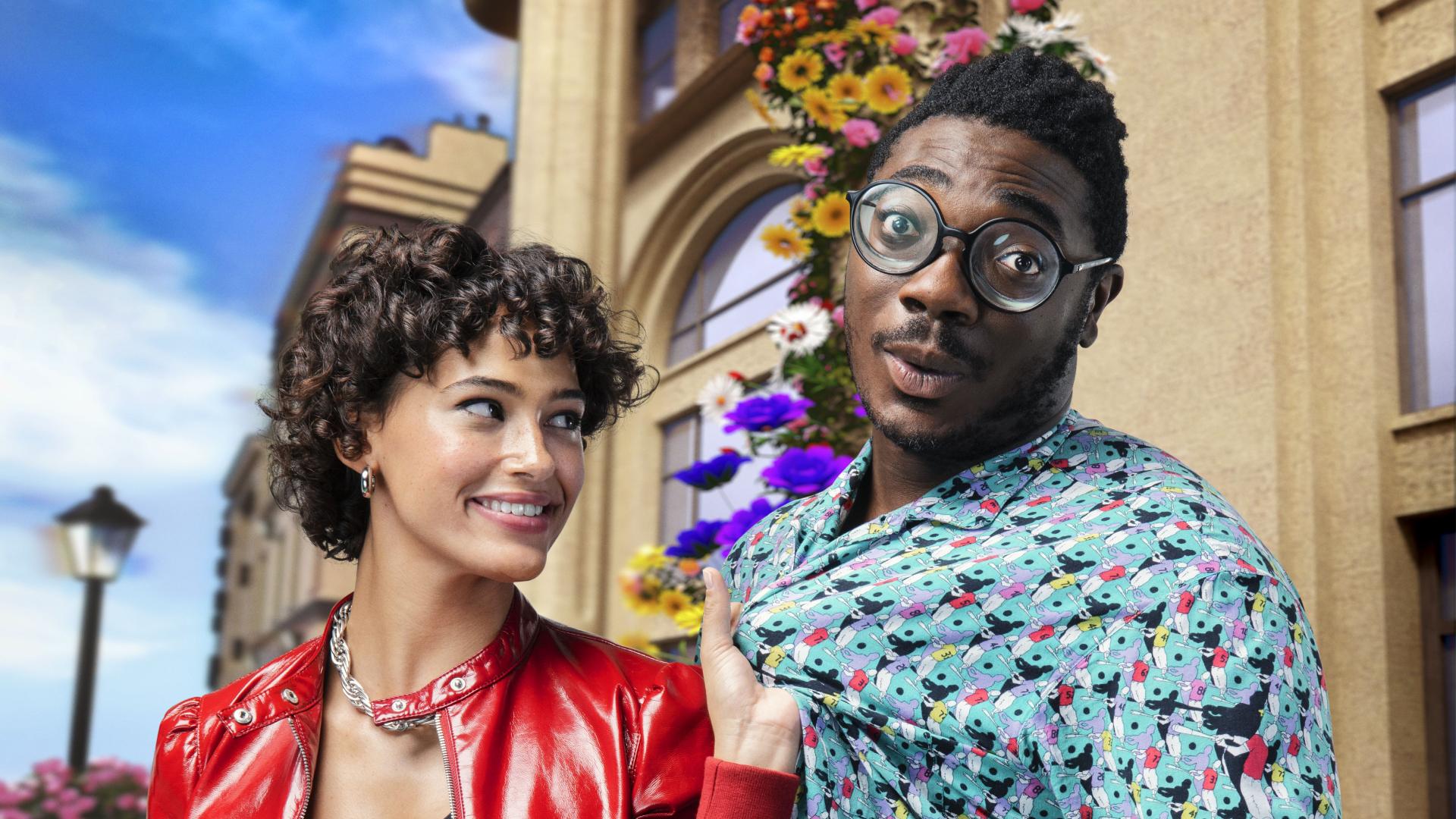 Vor einem historischen Gebäude zieht eine Frau lächelnd einem Mann am Hemd.