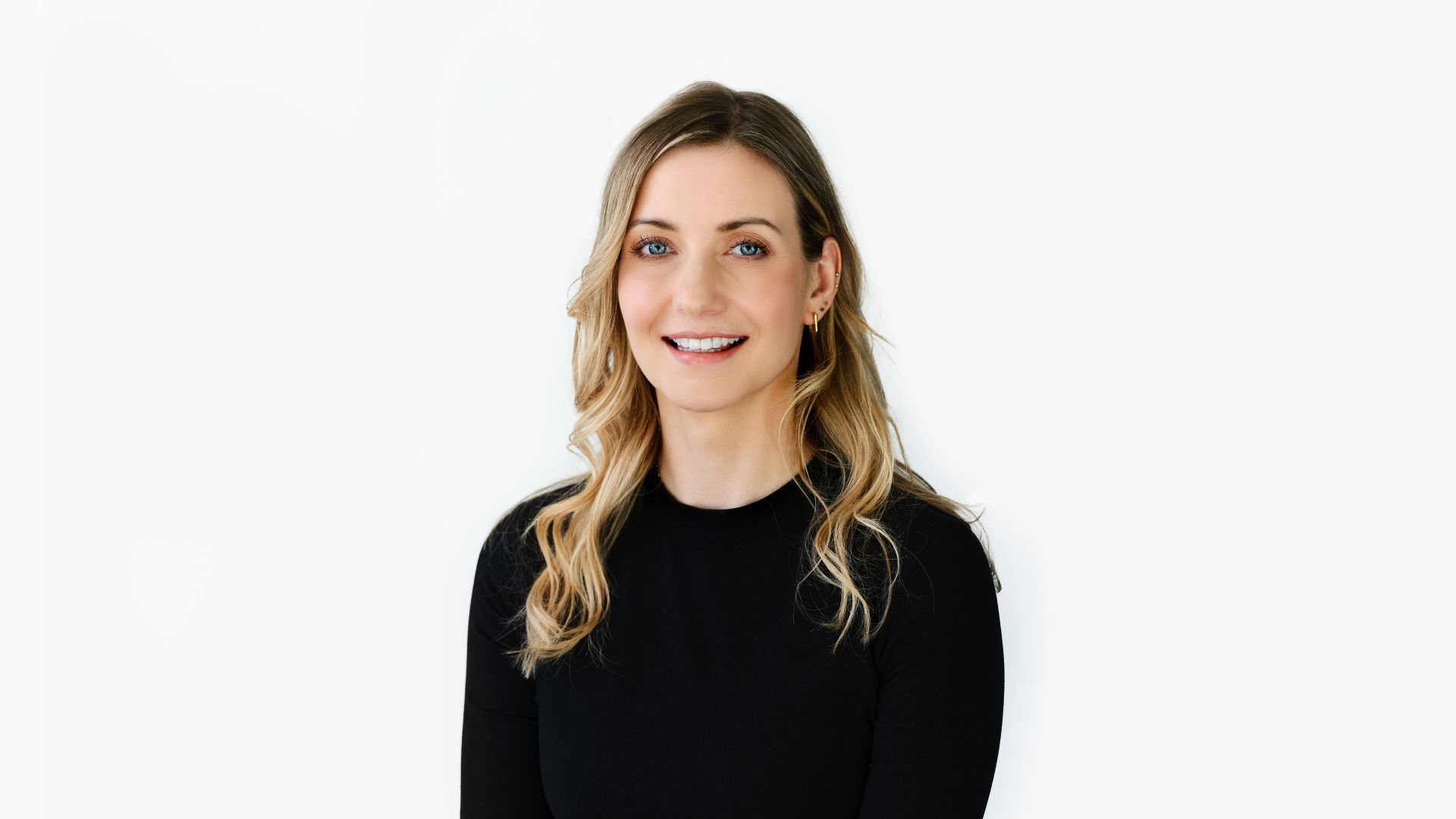 Sarah Potter, Influencer & Media Director für Unilever Personal Care, lächelt. Sarah ist eine blonde Frau in einem schwarzen Oberteil.