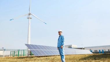 Ein Mann, vor Solarmodulen stehend