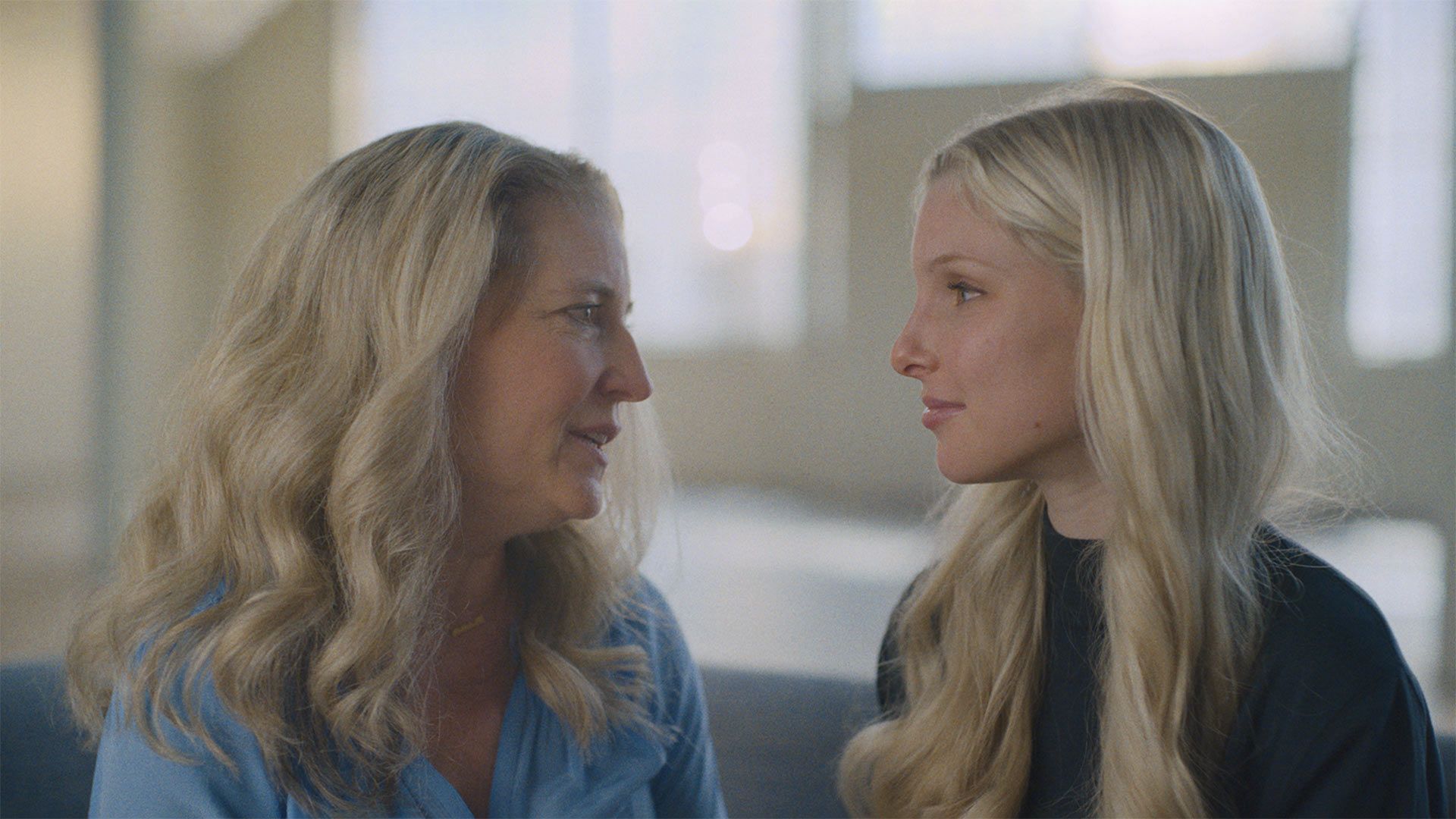 Eine Mutter schaut in das Gesicht ihrer jugendlichen Tochter.