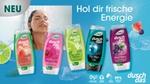 Fünf Duschgel-Flaschen der Marke duschdas, im Hintergrund eine Frau unter der Dusche.