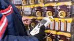 Eine Person misst die Temperatur gestapelter Magnum-Multipacks, das Thermometer zeigt -21,8 Grad Celsius an.