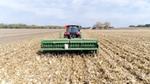 Landwirt auf einem Traktor bei der Arbeit mit Feldfrüchten